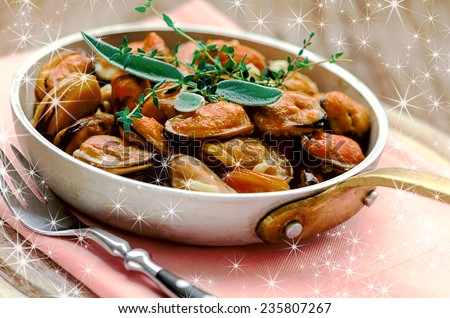 Mussels in cream and garlic sauce with provencal herbs in aluminum saucepan for Christmas and New Year party