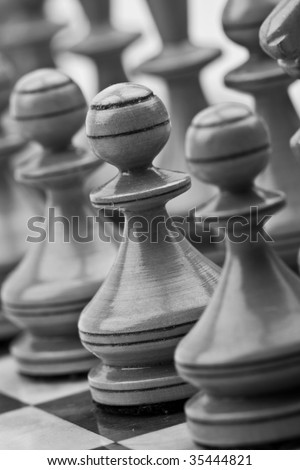 a gray scale picture of white pawns on a chessboard