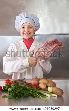 Cook woman with raw meat  in kitchen