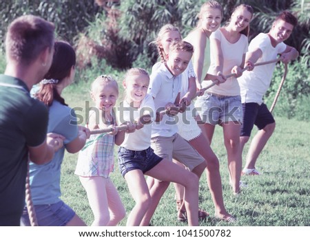 Happy Teenagers With Parents Playing Active Games In Summer Park Tugging War 1041500782 Happy Teenagers With Parents Playing Active Games In Summer Park Tugging War 1041500782