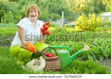Happy mature woman with basket of harvested vegetables