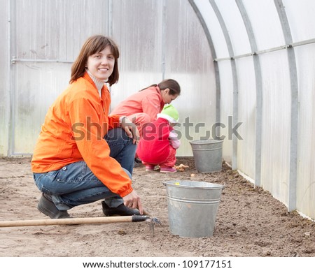 Happy family works in greenhouse
