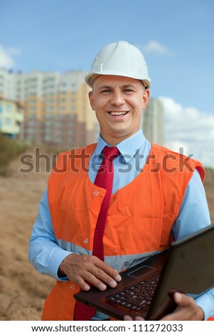 White-collar worker wearing protective helmet works on the building site