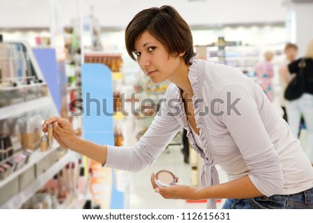woman chooses cosmetic  at cosmetics  shop