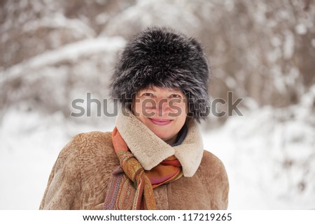 Outdoor winter portrait of mature woman in wintry forest