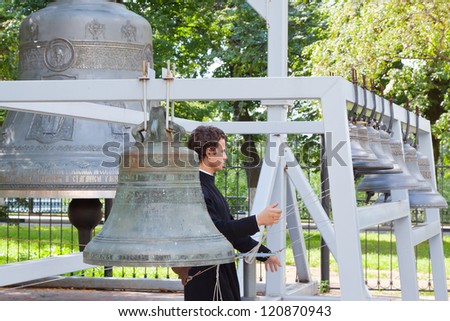 YAROSLAVL, RUSSIA - JULY 28: Monk rings the bell of Assumption cathedral in July 28, 2012 in Yaroslavl, Russia. Dormition Cathedral was built in 1215 and demolished in 1937. Now there is recovery