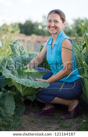 Mature woman  in plant of cabbage