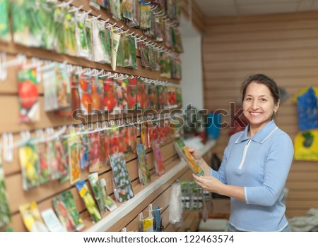 Smiling mature woman chooses the seeds at store