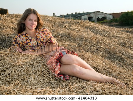 Country girl on fresh hay in summer