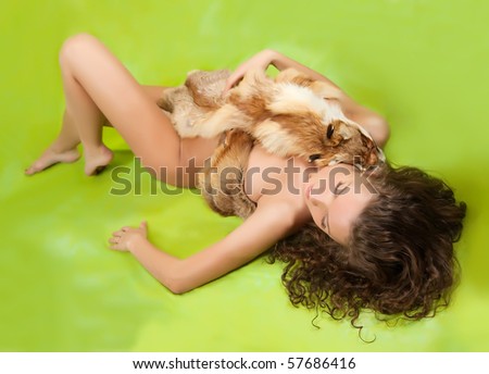 Nudity woman covered with a fox fur on green background