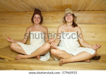 girl women in white sheet doing yoga  in sauna