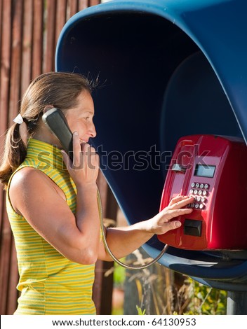 Senior woman  on the pay phone outdoor