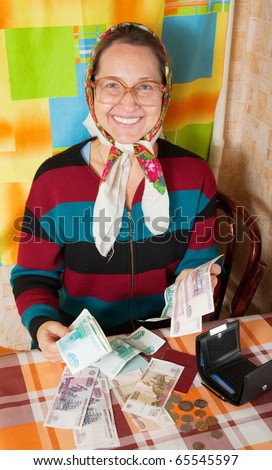 Portrait of happy senior woman with money  at home