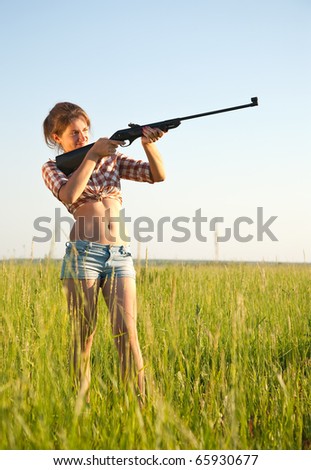 young girl aiming pneumatic air rifle outdoor