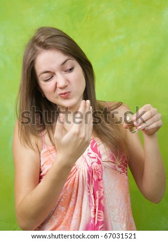 Beautiful young woman smelling bad perfume