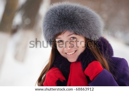 Portrait of beautiful woman in coat and fur cap