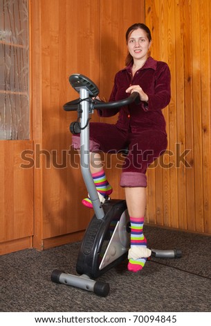 Girl workout on stationary bicycle at home