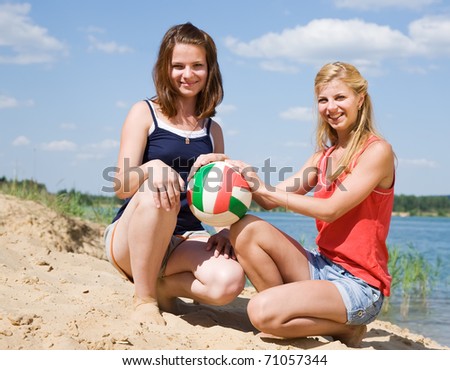 Portrait of sporty girls with volleyball on sand beach