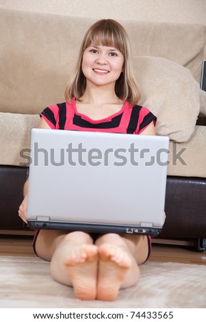 young woman sitting on floor and using laptop
