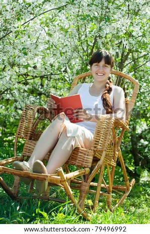Relaxing  girl reading book in bloom garden