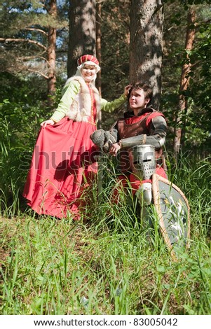 knight in armour and woman in historical costume  at forest