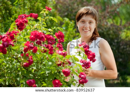 Female gardener in roses plant at garden