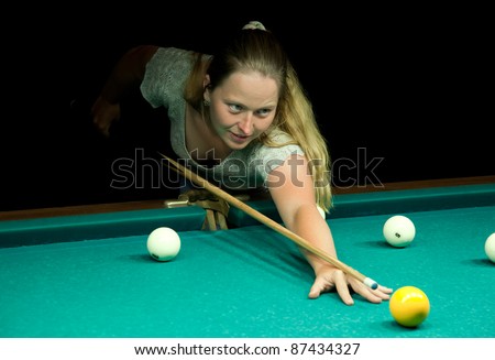 Casual dressed woman plays russian billiards