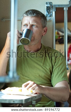 Middle-aged man drinks tea  in sleeper train