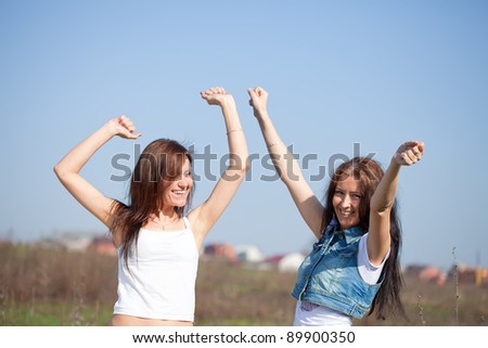 Two happy women together against sky