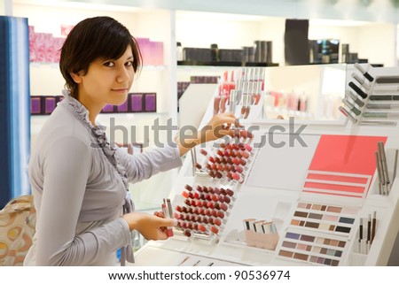 young girl is buying lipstick at cosmetics  shop
