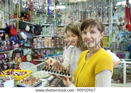 women  buying lipstick at cosmetics  shop