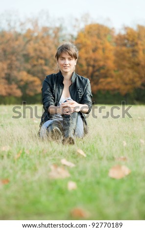 Girl in jacket and knee-high boots at autumn park