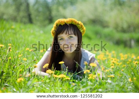 Happy  freckle girl relaxing in dandelion meadow