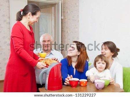 happy   family drinks tea and eats cakes at home