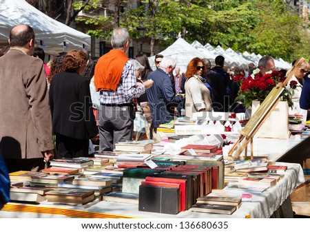 BARCELONA, SPAIN - APRIL 23: Books on street stalls in Saint George day in April 23, 2013 in Barcelona, Spain. Books and red roses - symbols of Saint George day feast in Catalunia