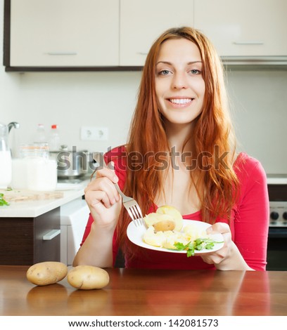 Casual positive girl eating jacket potatoes