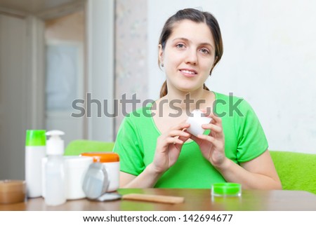 woman caring for her face with cosmetics at home