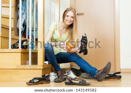 Woman sits on stairs and cleaning footwear