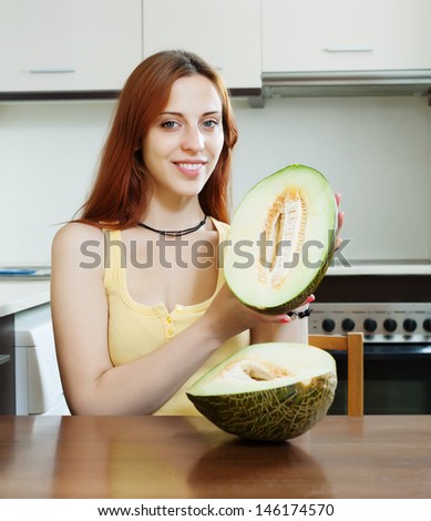 woman with ripe melon in home kitchen