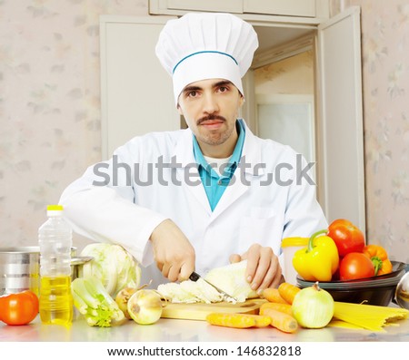 Portrait of male cook in toque with vegetables