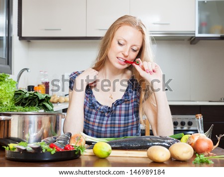 pensive housewife is thinking how to cook seabass fish at kitchen