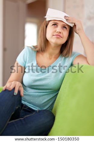 sick woman having headache holding towel on her head