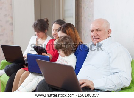 multigenerations family on sofa in livingroom  room with electronic devices at home