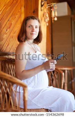 pregnant woman reads e-book in home interior