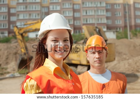 Portrait of two builders works at building site