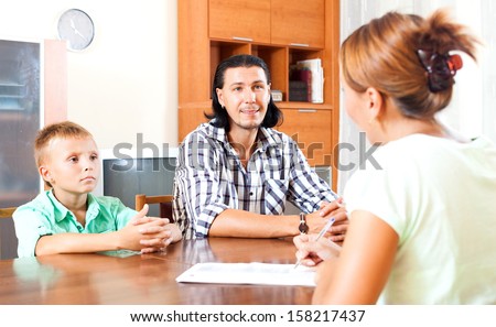 Son and father answer questions of a social worker in home
