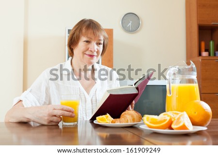 mature woman having breakfast with juice in morning