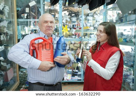 Mature man buys motor oil in auto parts store