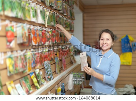 Female saleswoman with vegetable seeds at store