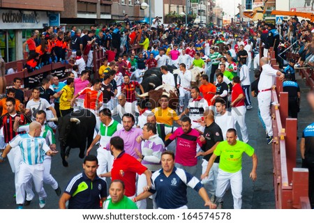 SAN SEBASTIAN DE LOS REYES, SPAIN - AUGUST 30: Encierro - Running of the Bulls in August 30, 2013 in San Sebastian de los Reyes, Spain. Running crowd of people and bulls